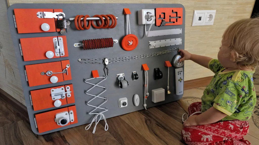 5 motivi per cui i pannelli Montessori sono tra i giocattoli migliori per i bambini piccoli 3 Pannelli montessori, bambino che gioca