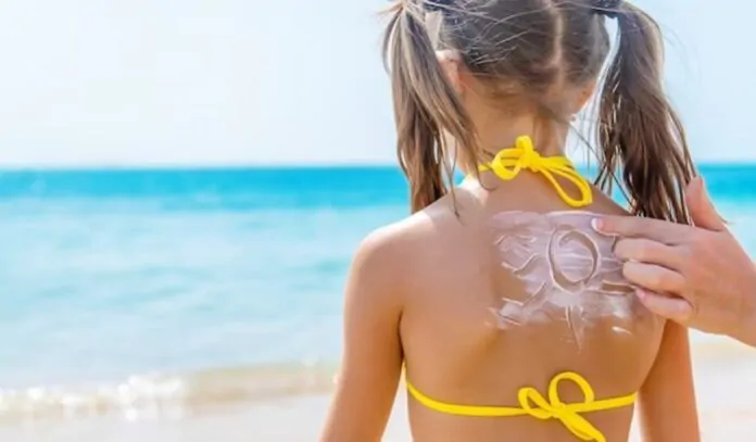 crema solare sulla pelle di una bambina di spalle