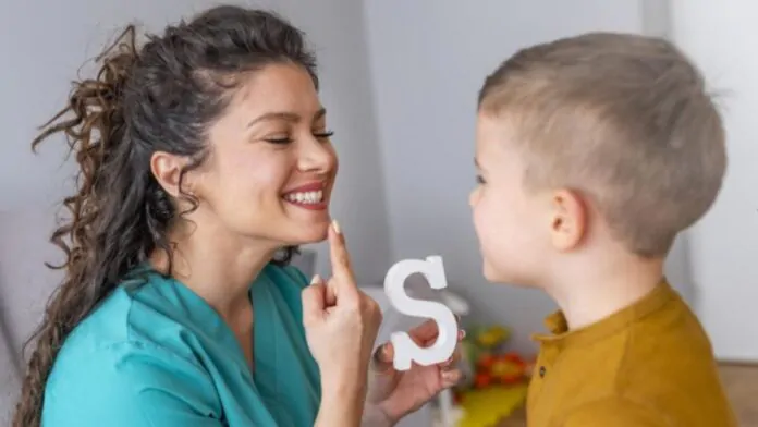 Una logopedista aiuta un bambino.