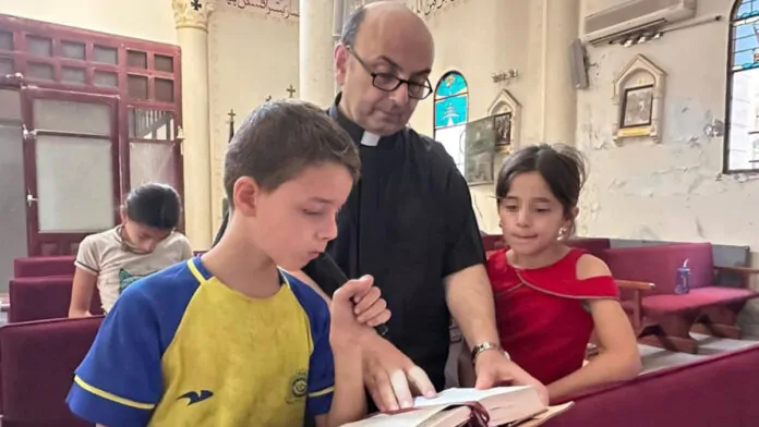 padre Gabriele romanelli con due bambini di gaza